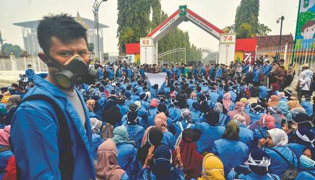 Hundreds of students gather to protest outside the office of the Riau Governor in Pekanbaru yesterday, demanding the government to do more to fight the raging forest fires in the region.