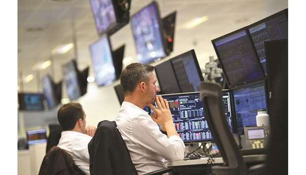Traders monitor share prices at the London Stock Exchange. The FTSE 100 was down less than 0.1% to 7,320.40 points yesterday.