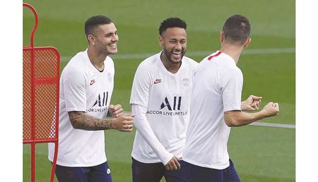 Paris Saint-Germainu2019s Neymar (centre) and Mauro Icardi (left) joke with a teammate during a training session at the clubu2019s Camp des Loges training grounds in Saint-Germain-en-Laye, west of Paris yesterday, on the eve of their Champions League Group A match against Real Madrid. (AFP)