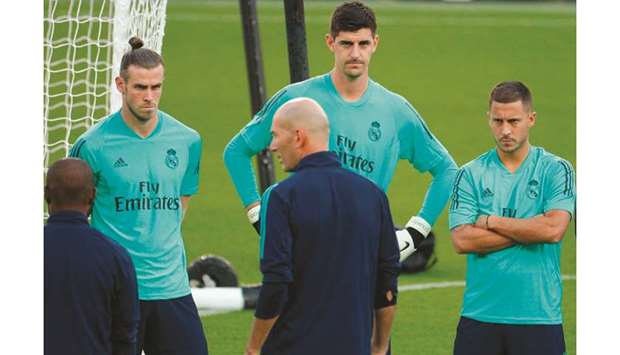 Real Madridu2019s Gareth Bale (left), Thibaut Courtois (centre) and Eden Hazard listen to coach Zinedine Zidane during a training session at the Parc des Princes stadium in Paris yesterday. (AFP)