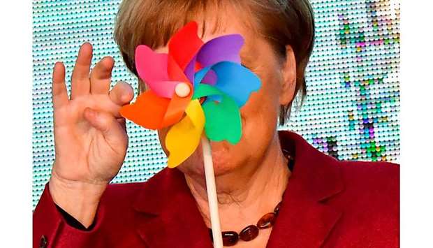 An April 16, 2019, file photo of German Chancellor Angela Merkel holding a toy wind wheel during the opening of the Arkona wind park in Sassnitz, northern Germany.