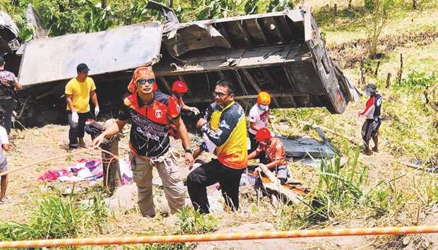 In this photo taken from social media, rescue workers stand next to a flatbed truck after it fell into a ravine in Tu2019Boli town, South Cotabato province,in the southern island of Mindanao, yesterday.