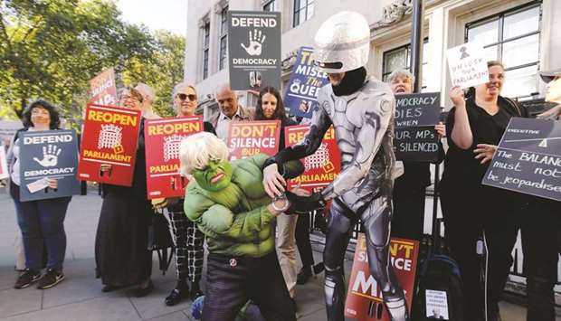 A protester dressed as comic character Incredible Hulk acts out an arrest with a protester dressed as film character Robocop outside the Supreme Court in central London on the first day of the hearing into the decision by the government to prorogue parliament.
