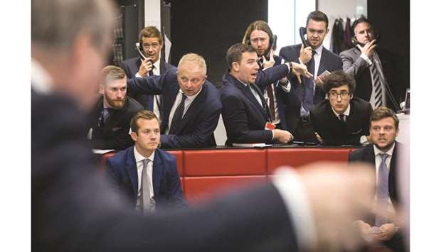 Traders react on the trading floor of the open outcry pit at the London Metal Exchange. The LME will postpone plans to ban metal tainted by human rights abuses until 2025, giving producers three more years to comply with guidelines and the exchange time to rethink its approach, industry sources said.