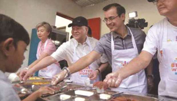 Manila Vice Mayor Maria Sheilah u2018Honeyu2019 Lacuna Pangan, San Miguel Corp. Chief Executive Officer Ramon Ang, Manila Mayor Francisco u2018Iskou2019 Domagoso and San Miguel Foods President Francisco Alejo serve food to children in Tondo, where the countryu2019s first Better World Food Bank was launched.
