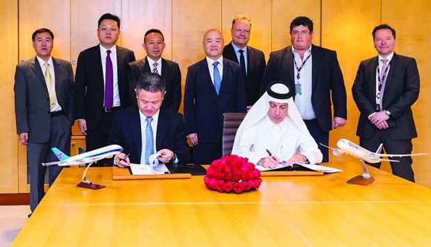 HE Akbar al-Baker and Wu Guoxiang sign the agreement as other officials look on.rnrn