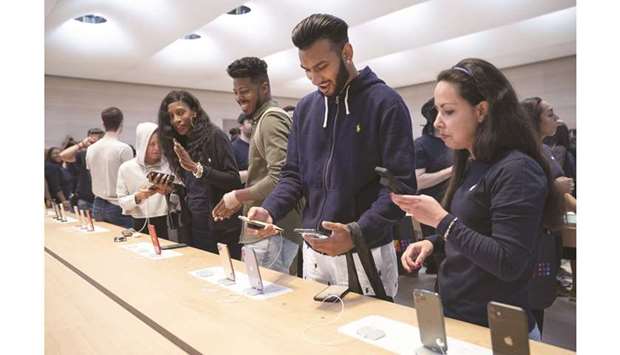 Customers shop for the new iPhone 11 at Appleu2019s flagship 5th Avenue store yesterday in New York City. The sales performance of the US tech giantu2019s latest line-up is being closely watched in the worldu2019s largest smartphone market, where Apple has been losing ground to competitors with cheaper and feature-packed handsets in recent years.
