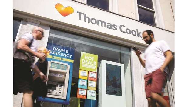 Pedestrians walk past a branch of Thomas Cook travel agentu2019s shop in London. Thomas Cook needs to find an extra u00a3200mn to satisfy its lenders or one of the worldu2019s oldest holiday company risks collapse, potentially stranding thousands of holidaymakers across Europe.