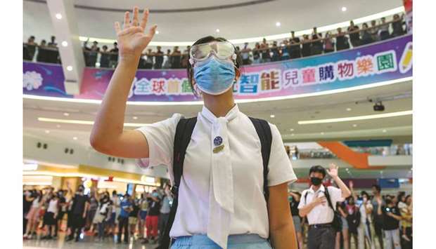 A high-school student raises her hand, as the gesture of u2018Five demandsu2019, and chants slogans in a shopping mall after a human chain rally in Tsuen Wan district in Hong Kong yesterday.