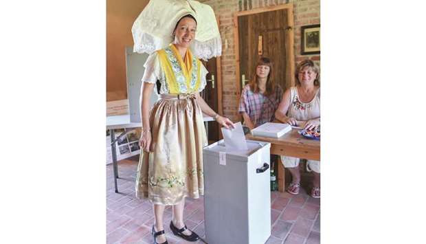 A woman in a traditional Sorbian dress casts her ballot during Brandenburg state elections, at a Burg polling station, in the Spreewald region of eastern Germany.