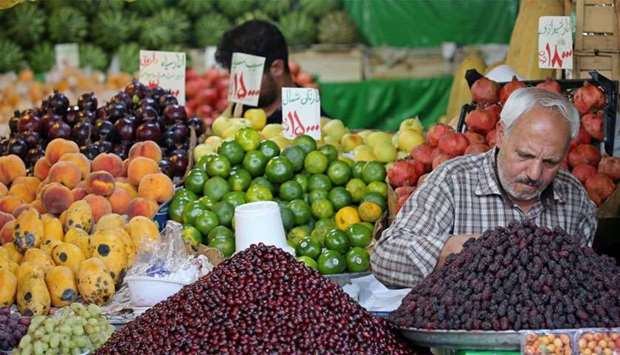 An Iranian fruit vendor adjusts his fruit shop in the Tajrish Bazaar in capital Tehran