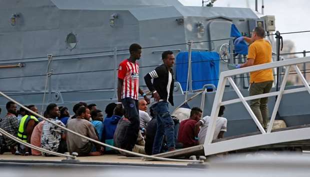 A police officer speaks to rescued migrants after they arrived on an Armed Forces of Malta patrol boat in Valletta's Marsamxett Harbour, Malta
