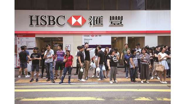 Pedestrians wait to cross a road in front of an HSBC Holdings bank branch in Hong Kong. The bank has launched a public-relations offensive aimed at leaders in Beijing, reflecting worries that its position as the biggest foreign bank in China is at risk.