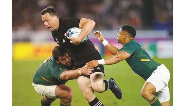 New Zealandu2019s Ben Smith (centre) attempts to evade a tackle by South Africau2019s Frans Malherbe (left) during their Pool u2018Bu2019 match in Yokohama yesterday. (AFP)