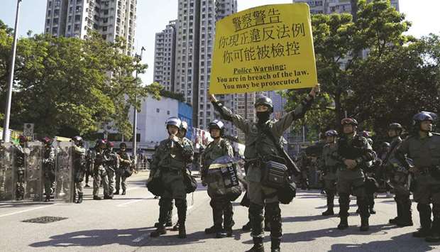 Riot police hold a sign during an anti-government march in Tuen Mun, Hong Kong, yesterday.