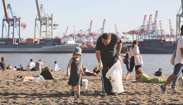 A man and his daughter collect rubbish from the banks of the river Elbe in Hamburg, northern Germany, during u2018International World Clean-up Dayu2019.