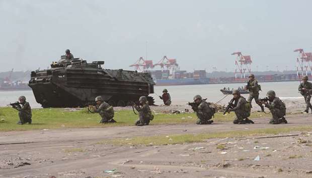 Marines take their position next to newly-acquired Amphibious Assault Vehicles (AAV) during an amphibious landing exercise at the lighthouse beach facing South China Sea in Subic Freeport in Subic town, Zambales province, north of Manila, yesterday, as part of the combined exercise between Army, Navy, Air Force and Marines.