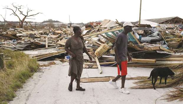 People walk among debris at the Mudd neighbourhood, devastated after Hurricane Dorian hit.