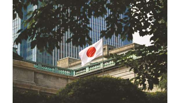 A Japanese national flag flies outside the Bank of Japan headquarters in Tokyo (file). The BoJ has been a key player in Prime Minister Shinzo Abeu2019s plan to reflate the economy with a mix of monetary stimulus and fiscal spending. It now holds 43% of the national debt, which is the worldu2019s largest.