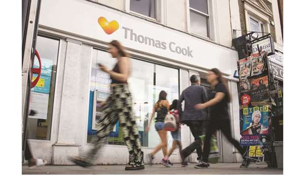 Pedestrians walk past a branch of a Thomas Cook travel agentu2019s shop in London. The British government has plans in place to bring home stranded holidaymakers if Thomas Cook goes out of business, an event that would likely spark chaotic scenes at resorts and airports around the world.