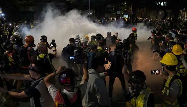 Members of the media react to the tear gas fired by the police in Tuen Mun, Hong Kong