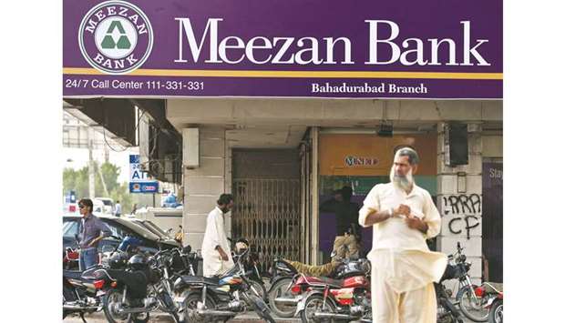 Pedestrians pass in front of a branch of the Meezan Bank in Karachi. According to the latest Islamic Banking Bulletin issued by the State Bank of Pakistan on September 13, the network of Islamic banks in Pakistan currently consists of 22 institutions, including five fully-fledged Islamic banks and 17 conventional banks with standalone Islamic banking branches. Among the Islamic banks, the largest is Meezan Bank with 678 branches.