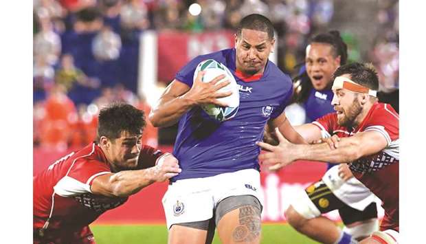 Samoau2019s Ed Fidow (centre) brakes through the Russian defence and runs to score a try  during their Pool A match at the Kumagaya Rugby Stadium in Kumagaya, Japan, yesterday. (AFP)
