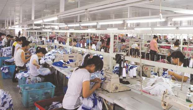 Workers make Orolay jackets at the companyu2019s factory complex in Jiaxing, Zhejiang province. Chinau2019s economy will probably grow 6.2% this year, the ADB said yesterday, weaker than its 6.3% projection in July.