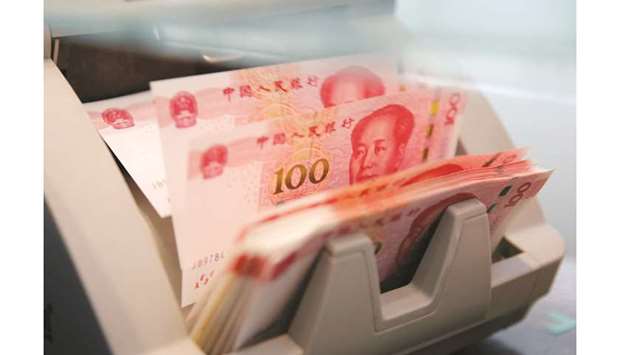 Chinese 100 yuan banknotes are seen in a counting machine at a branch of a commercial bank in Beijing (file). China recently scrapped investment limits for foreigners as it seeks to encourage more inflows into its capital markets and increase the yuanu2019s global use.