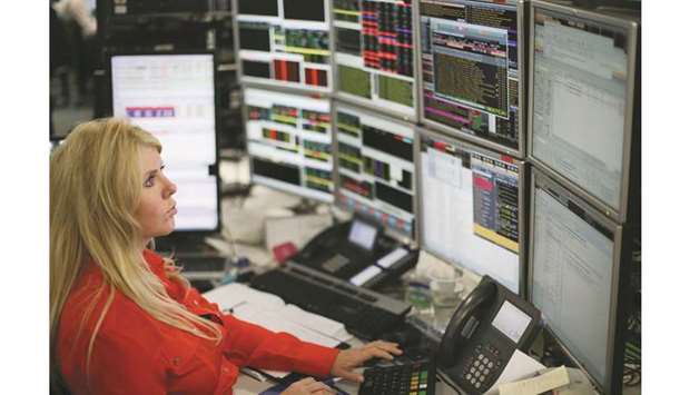 A trader works at the London Stock Exchange. Londonu2019s blue-chip FTSE 100 index finished yesterday down less than 0.1% at 7,289.99 points.