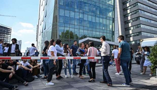 Office workers gather after fleeing their buildings in the Maslak District of Istanbul
