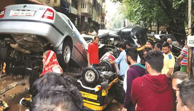 Residents inspect damaged vehicles after heavy rains lashed Pune, Nashik, and surrounding areas.