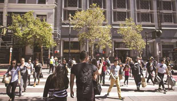 Shoppers and pedestrians walk along Market Street in San Francisco, California. US consumer spending barely rose in August and business investment remained weak, suggesting the economy was losing momentum as trade tensions linger.