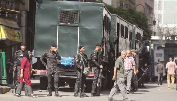 Police watch as people cross the street in Ramses Square in Cairo, yesterday.