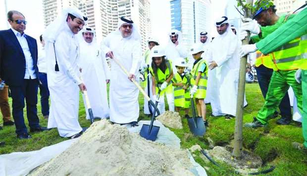 Ashghal president Dr Saad bin Ahmed al-Mohannadi and other officials take part in a tree-planting exercise along with schoolchildren.