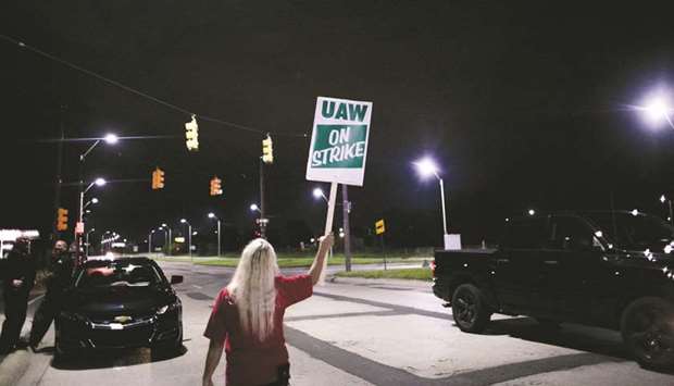 A demonstrator holds a sign reading u201cUAW on Strikeu201d during a United Auto Workers strike outside the General Motors Co Hamtramck assembly plant in Detroit, Michigan on September 15. Dread over the prospect that plug-in cars u2013 which have fewer parts and require less labour to build u2013 will doom auto jobs helped spark the first UAW strike in over a decade. Ford Motor Co and Fiat Chrysler Automobiles, which are rolling their own battery-powered models to market in the coming years, could face a similar fate if theyu2019re unable to quell the UAWu2019s concerns that widespread adoption of EVs endangers the employment of 35,000 union members.