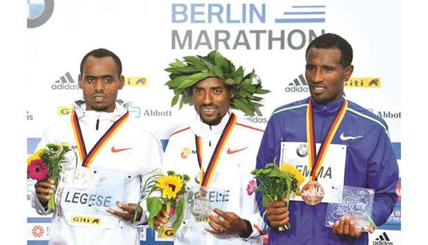 (L to R) Second-placed Birhanu Legese of Ethiopia, winner Ethiopiau2019s Kenenisa Bekele and third-placed Sisay Lemma of Ethiopia pose during the medal ceremony of the Berlin Marathon in Berlin. (AFP)