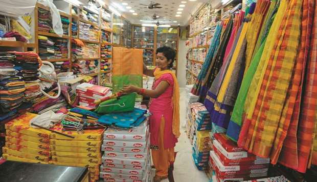A sales woman arranges saris inside at a shop ahead of upcoming Dushhera festival in Hyderabad. Amazon and Flipkart yesterday launched a crucial battle for shoppers as retailers search for a much-needed boost to sales in a slowing economy.