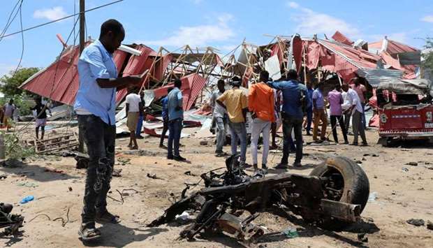 Somalis inspect the damage caused at the scene of an attack on an Italian military convoy in Mogadishu