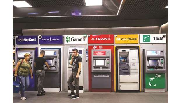 A row of automated teller machines (ATM) operated by (from left) Yapi ve Kredi Bankasi; Turkiye Is Bankasi, also known as Isbank; Turkiye Garanti Bankasi; Akbank Turk; Turkiye Vakiflar Bankasi and Turk Ekonomi Bankasi, also known as TEB, sit at the Gayrettepe metro station in Istanbul (file). The lirau2019s recovery from its crash late last year is also helping some lenders cut interest rates on syndicated loans by as much as 10%.