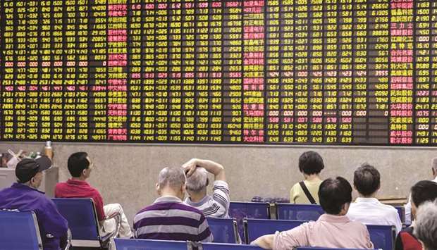 Investors sit in front of an electronic stock board at a securities brokerage in Shanghai. The Shanghai Stock Exchange rose 1.3% to 2,924.11 points yesterday after a better-than-expected reading on Chinese factory activity.