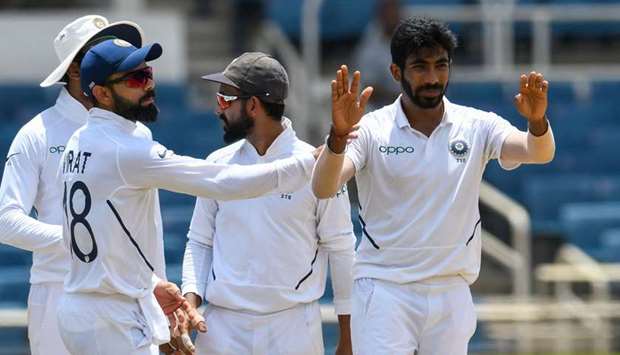 Virat Kohli (left) and Jasprit Bumrah (right) of India celebrate the dismissal of Jermaine Blackwood of West Indies during Day 4 of the 2nd Test at Sabina Park, Kingston, Jamaica, yesterday. (AFP)