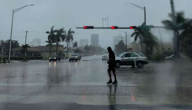A man crosses the street during a pouring rain in Fort Lauderdale, Florida on Monday