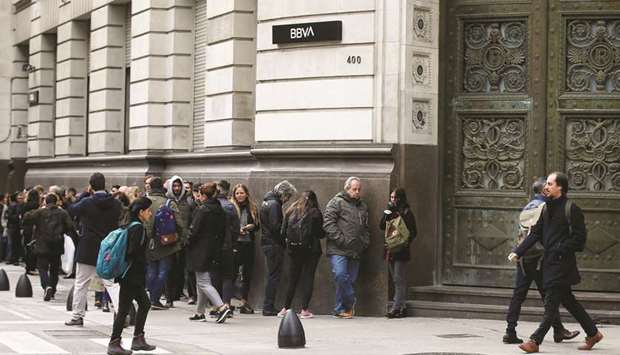 People line up outside BBVA bank before its opening, in Buenos Aires, Argentina, yesterday.
