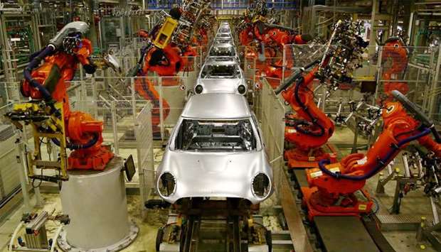 Robotic arms work on the bodyshells of Mini cars as they pass along a section of automated production line