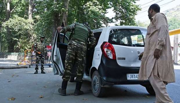 An Indian paramilitary soldier searches a car at a roadblock during a lockdown in Srinagar. AFP