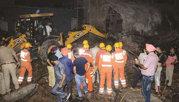 Rescue workers gather at the site of a deadly explosion at a firecracker factory in Batala in Punjab yesterday.