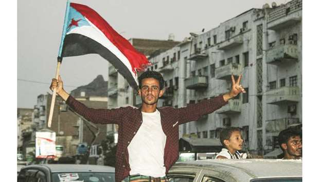 A man flashes the victory gesture as he flies the flag of south Yemen as Yemenis gather ahead of a demonstration called by the Southern Transitional Council (STC) which seeks independence for south Yemen, at Al-Maala square in the centre of the second city of Aden, yesterday.