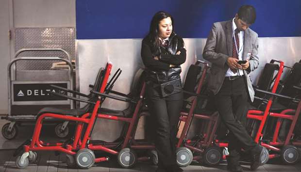 Employees stand near traveller transport wheelchairs at LaGuardia Airport in the Queens borough of New York. Passenger requests for wheelchair assistance received by airlines have been increasing globally in the recent years.