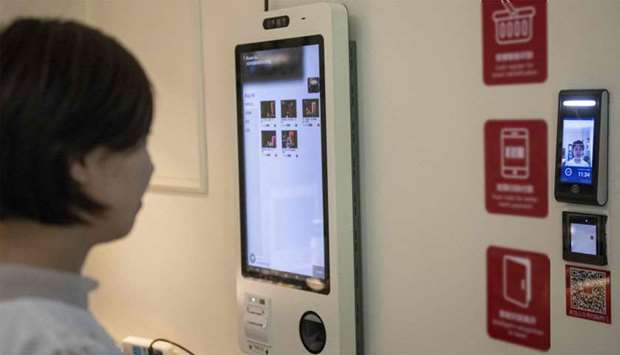 A woman uses a facial recognition device